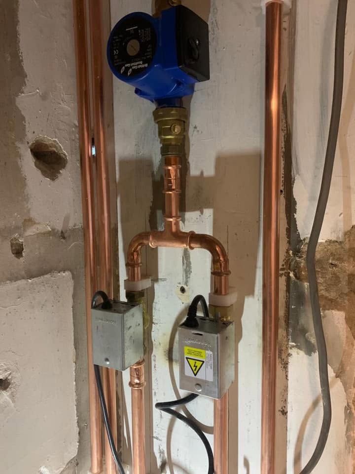 Close up of the pump, valves and copper pipework on the cylinder installation